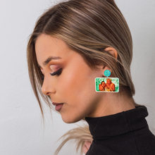 Load image into Gallery viewer, A girl looking downward, showing off her New Girl earrings featuring Tran holding Nick Miller in the pool as he cringes