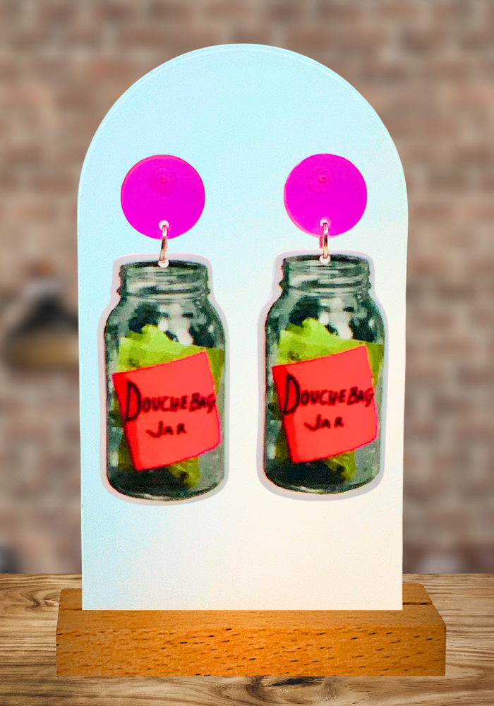 Earrings with neon pink studs and a dangling “Douchebag Jar” earring from New Girl