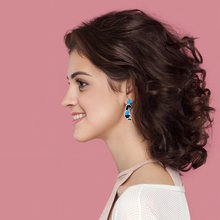 Load image into Gallery viewer, Earrings against a bright blue backdrop featuring Tina Belcher from Bob’s Burgers dancing