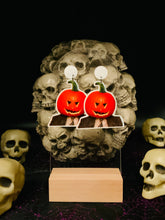 Load image into Gallery viewer, Earrings featuring Dwight Schrute from “The Office” with a pumpkin stuck on his head, set against a spooky Halloween skull background, blending the humor of his antics with classic Halloween imagery