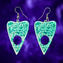 Load image into Gallery viewer, A pair of aqua blue translucent Ouija planchette earrings, perfect for adding a fun and mystical touch to your Halloween look.