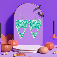 Load image into Gallery viewer, A pair of aqua blue translucent Ouija planchette earrings, on a purple mount, perfect for adding a fun and mystical touch to your Halloween look.