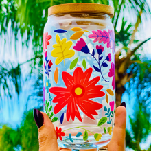 Load image into Gallery viewer, A 16 oz glass cup with a vibrant floral design featuring colorful flowers, leaves, and petals. Includes a bamboo lid and reusable glass straw, perfect for cold drinks. BPA-free, handwash only, and eco-friendly.