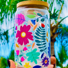 Load image into Gallery viewer, A 16 oz glass cup with a vibrant floral design featuring colorful flowers, leaves, and petals. Includes a bamboo lid and reusable glass straw, perfect for cold drinks. BPA-free, handwash only, and eco-friendly.