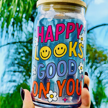 Load image into Gallery viewer, A 16oz BPA-free glass cup featuring a retro-inspired UVDTF design with smiley faces, daisies, and the phrase "Happy Looks Good on You," complete with a bamboo lid and reusable glass straw.