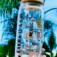 Load image into Gallery viewer, A 20 oz glass cup featuring colorful cat illustrations and Taylor Swift album-inspired designs, with the phrase "Karma is a Cat," paired with a bamboo lid and glass straw. Perfect for Swifties and cold drink lovers.
