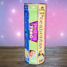 Load image into Gallery viewer, A 20 oz stainless steel insulated tumbler featuring a vibrant design with vintage Disney princess VHS covers, including Sleeping Beauty, The Princess and the Frog, and Pocahontas. Comes with a clear lid, metal straw, and straw cleaner, perfect for hot and cold drinks.