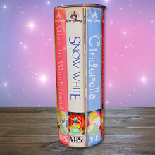 Load image into Gallery viewer, A 20 oz stainless steel insulated tumbler featuring a vibrant design with vintage Disney princess VHS covers, including Alice in Wonderland, Snow White and the Seven Dwarfs, and Cinderella. Comes with a clear lid, metal straw, and straw cleaner, perfect for hot and cold drinks.