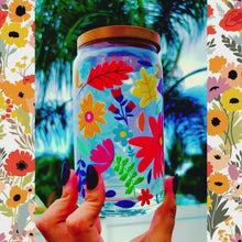 Load and play video in Gallery viewer, A 16 oz glass cup with a vibrant floral design featuring colorful flowers, leaves, and petals. Includes a bamboo lid and reusable glass straw, perfect for cold drinks. BPA-free, handwash only, and eco-friendly.