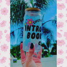 Load and play video in Gallery viewer, A 20oz BPA-free glass cup with a floral UVDTF wrap featuring the text "Lifetime Member: Introverted Bookworm Club," paired with a bamboo lid and glass straw. Ideal for bookworms and iced coffee enthusiasts.