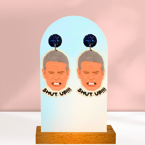 Earrings featuring a drawing of Andy Cohen from the Real Housewives of New York reunion yelling 