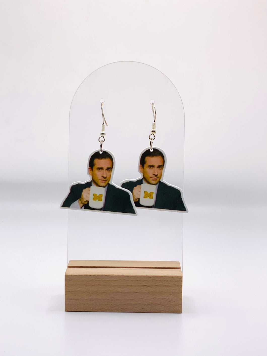  Earrings depicting Michael Scott from “The Office” holding his coffee mug with the University of Michigan logo, capturing his proud yet clueless smile in a design that blends TV fandom with collegiate spirit.