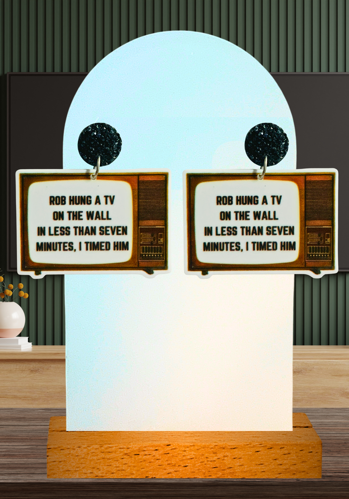 Earrings featuring a TV set with Scheana Shay's quote: “Rob hung a TV on the wall in less than seven minutes, I timed him” from Vanderpump Rules.