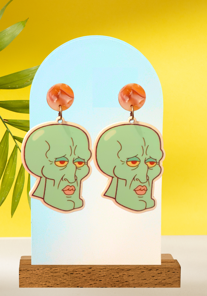 Handsome Squidward earrings photographed on a yellow background