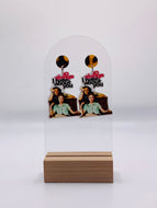 Handcrafted acrylic earrings showcasing the iconic '10 Things I Hate About You' movie poster design. The earrings feature a vibrant image featuring Julia Stiles leaning against Heath Ledger. The bold typography says 