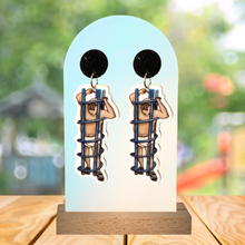 Load image into Gallery viewer, Earrings featuring Frank Reynolds stuck in a  playground coil with a playground background
