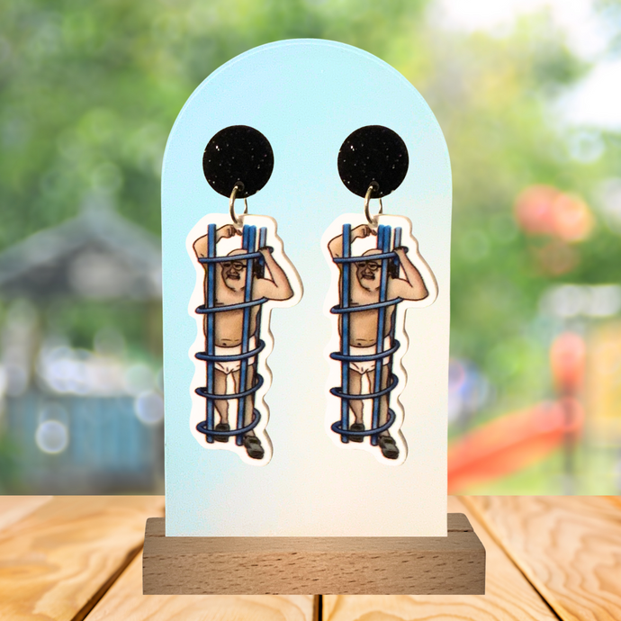 Earrings featuring Frank Reynolds stuck in a  playground coil with a playground background