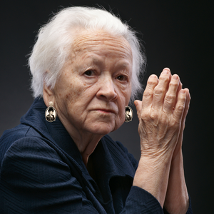 An old woman wearing earrings featuring a smiling Blanche from Golden Girls with the snarky saying "Eat Dirt and Die, Trash" underneath