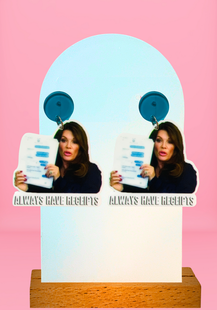 Earrings featuring Lisa Vanderpump holding up a printed log of texts with the quote “always have receipts” from Real Housewives of Beverly Hills.