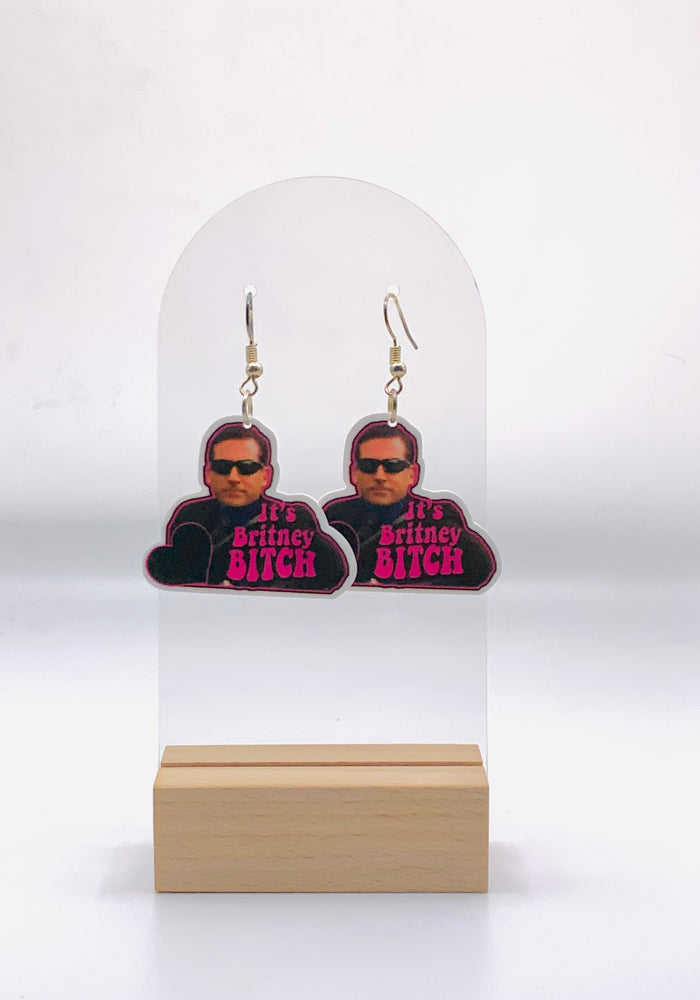  Earrings featuring the humorous quote 'It's Britney, Bitch', a nod to Michael Scott's pop culture mix-up from 'The Office'. Designed for fans of the show, Britney Spears, and Lady Gaga, these earrings make a bold fashion statement that reflects a love for television comedy and pop diva moments.