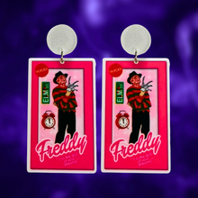 Load image into Gallery viewer, Earrings featuring Freddy Krueger in a Barbie-style box, with an Elm Street sign and alarm clock, ideal for fans of horror movies and playful Halloween fashion.
