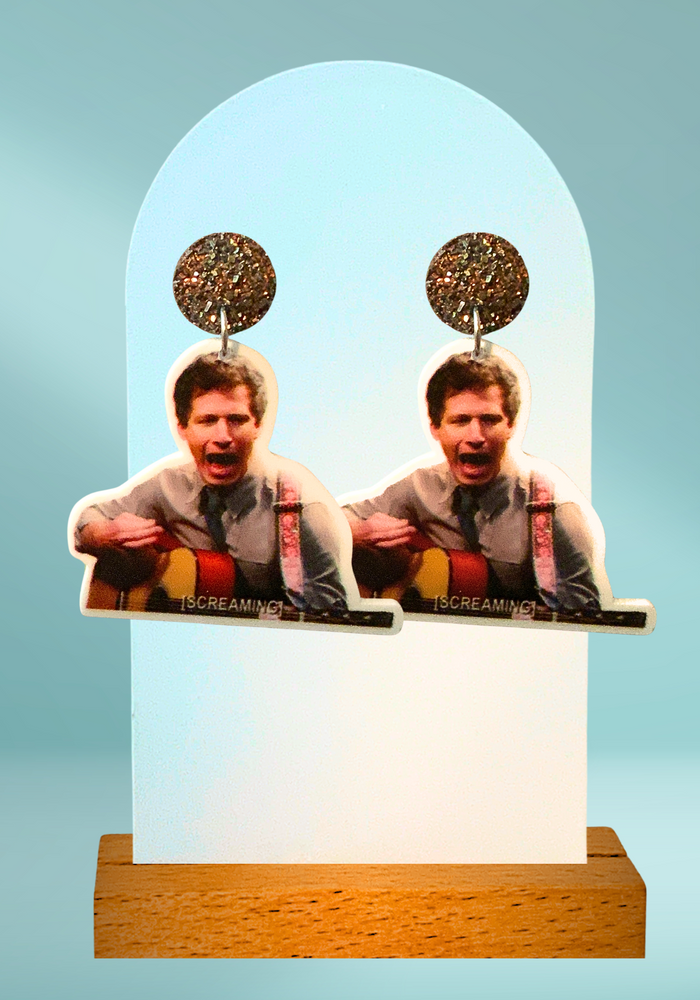 Earrings with a photo of Andy Samberg as Jake Peralta playing guitar with the caption [SCREAMING] from Brooklyn Nine-Nine