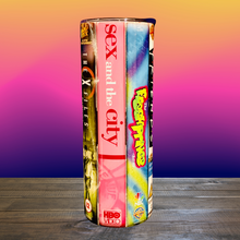 Load image into Gallery viewer, A 20 oz stainless steel insulated tumbler featuring a vinyl wrap of VHS covers from iconic &#39;90s TV shows, including Friends, The Sopranos, The Fresh Prince of Bel-Air, and Sex and the City. Comes with a lid and reusable straw, perfect for nostalgic TV lovers.
