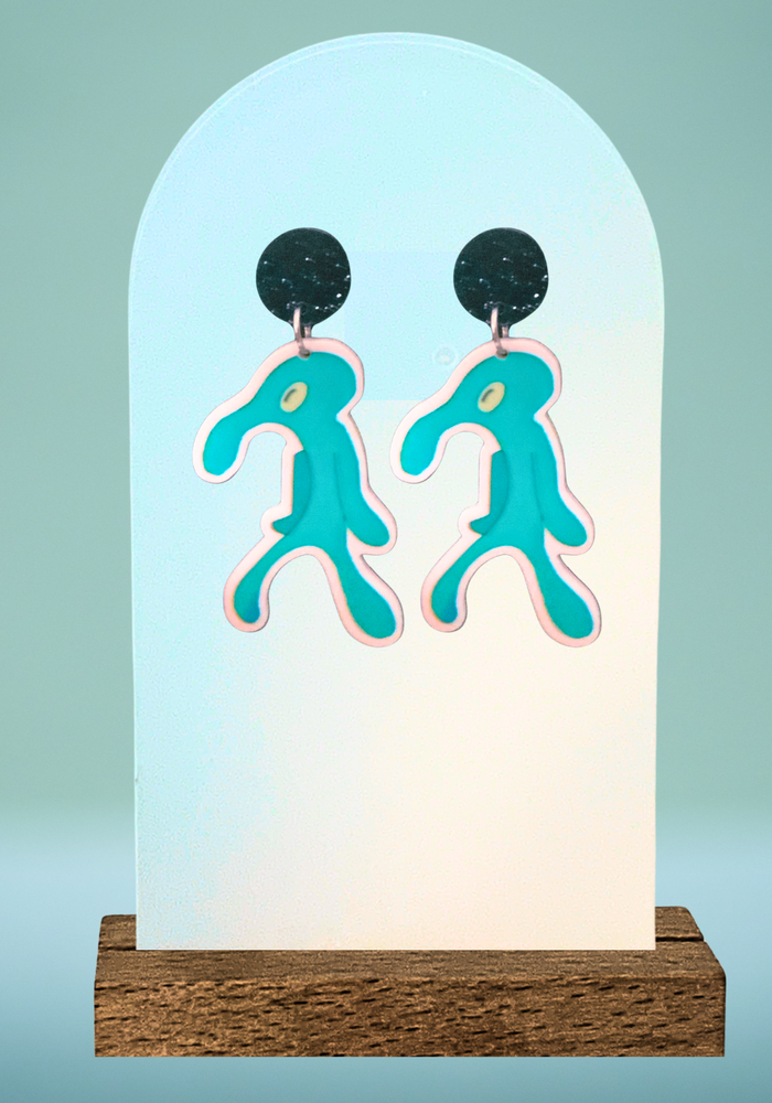 Earring display on a blue background displaying earrings with an artsy squidward cutout- Bold and Brash