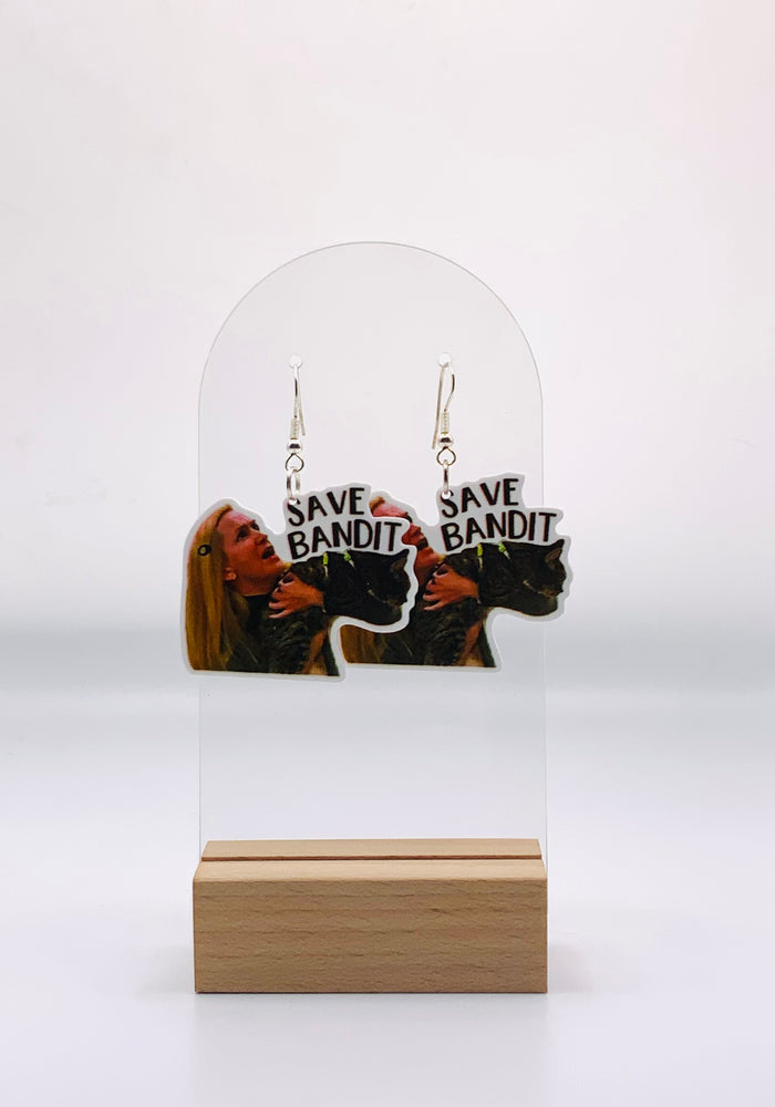 Earrings featuring Angela Martin from 'The Office' in the midst of her hilarious 'Save Bandit' escapade, where she attempts to rescue her cat during a chaotic fire drill by throwing it through the ceiling tiles.