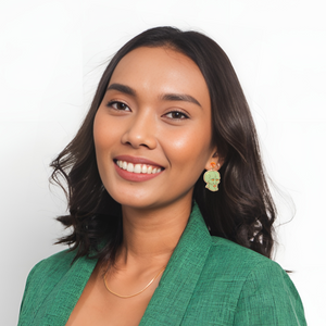 A woman smiling wearing handsome squidward earrings