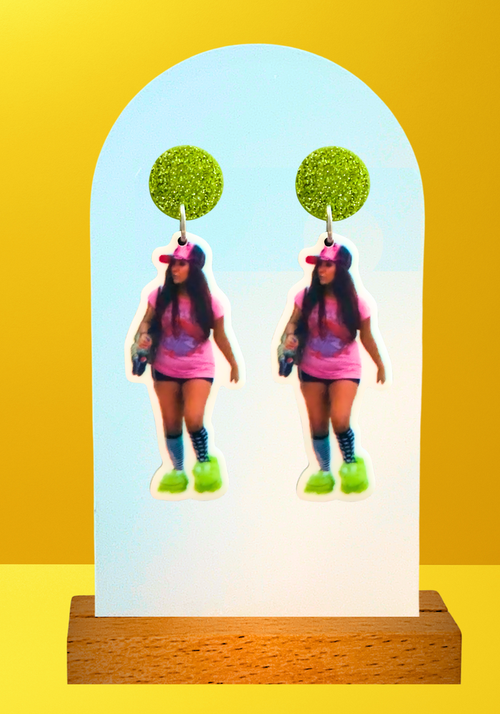 Earrings featuring a photo of Snooki from Jersey Shore wearing dragon slippers, on a yellow photo backdrop
