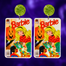 Load image into Gallery viewer, Earrings featuring a vintage Halloween Barbie comic cover from 1993, showing Barbie handing out candy to trick-or-treaters, perfect for fans of Barbie and nostalgic Halloween accessories. Displayed on a purple backdrop.
