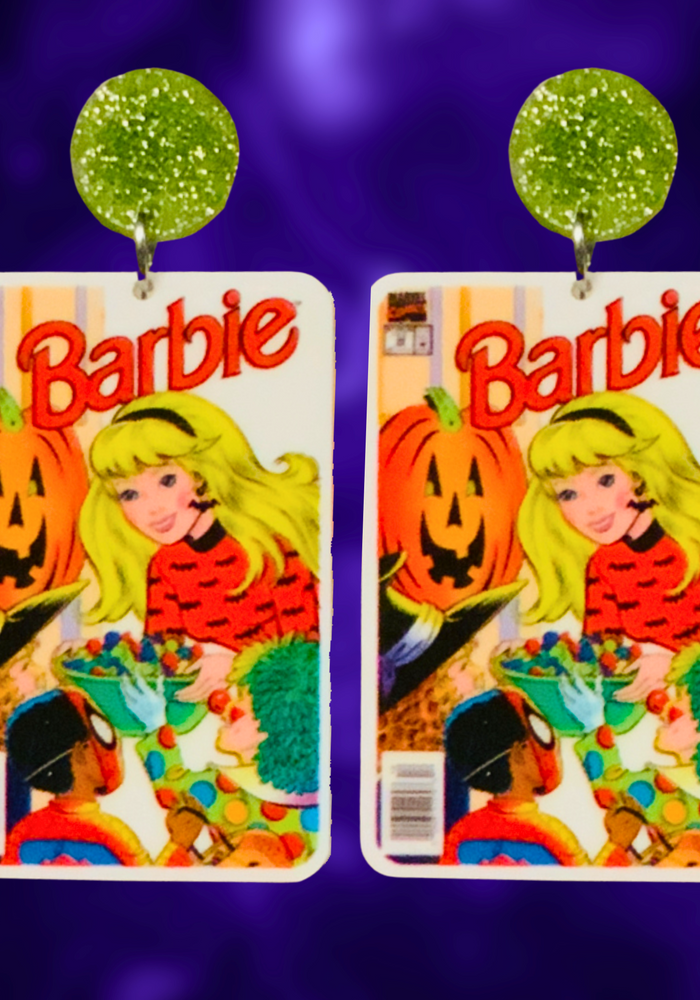 Earrings featuring a vintage Halloween Barbie comic cover from 1993, showing Barbie handing out candy to trick-or-treaters, perfect for fans of Barbie and nostalgic Halloween accessories. Displayed on a purple backdrop.