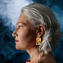 Load image into Gallery viewer, A model in front of a smoky background wearing earrings that feature a vintage Halloween Barbie comic cover from 1993, showing Barbie handing out candy to trick-or-treaters, perfect for fans of Barbie and nostalgic Halloween accessories
