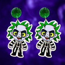 Load image into Gallery viewer, A purple background with earrings featuring a cute cartoon version of Beetlejuice, perfect for fans of the classic film and nostalgic Halloween fun.
