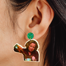 Load image into Gallery viewer, A close-up of an ear wearing a green gem stud with an earring of Kitty Forman from That 70s Show pouring a bottle of liquor into a blender
