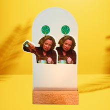 Load image into Gallery viewer, Vibrant yellow background featuring a wooden earring stand with images on green gems featuring Kitty Foreman pouring an entire bottle of liquor into a blender
