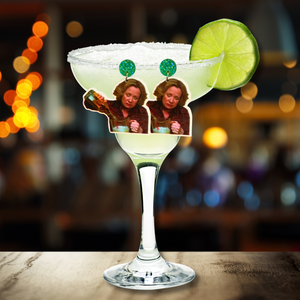 A bar scene with a margarita glass. Earrings featuring Kitty Forman from That 70s show are propped up on the margarita glass, and the earrings feature Kitty pouring a bottle of liquor directly into a blender.