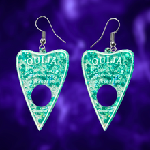 Load image into Gallery viewer, A pair of aqua blue translucent Ouija planchette earrings, perfect for adding a fun and mystical touch to your Halloween look.
