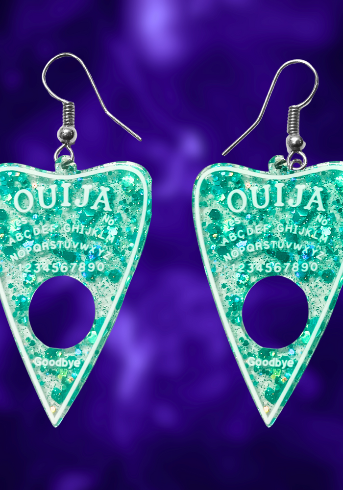 A pair of aqua blue translucent Ouija planchette earrings, perfect for adding a fun and mystical touch to your Halloween look.