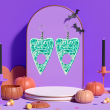 Load image into Gallery viewer, A pair of aqua blue translucent Ouija planchette earrings, on a purple mount, perfect for adding a fun and mystical touch to your Halloween look.
