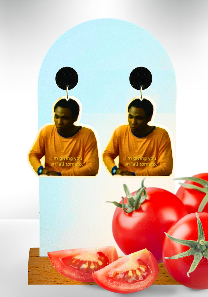 Earrings on a white background with tomatoes in front featuring Troy Barnes from 