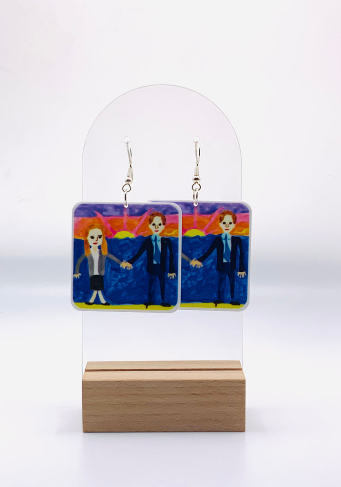 Earrings featuring a replica of Michael Scott's unforgettable, quirky wedding gift to Jim and Pam from 'The Office'. An amateur wedding painting of Jim and Pam painting by Michael.