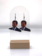 Earrings featuring Michael Scott’s memorable pained expression from the ‘Branch Closing’ episode of “The Office,” a humorous accessory for any fan of the series.
