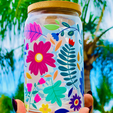 Load image into Gallery viewer, A 16 oz glass cup with a vibrant floral design featuring colorful flowers, leaves, and petals. Includes a bamboo lid and reusable glass straw, perfect for cold drinks. BPA-free, handwash only, and eco-friendly.
