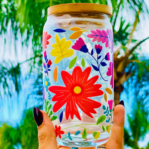 A 16 oz glass cup with a vibrant floral design featuring colorful flowers, leaves, and petals. Includes a bamboo lid and reusable glass straw, perfect for cold drinks. BPA-free, handwash only, and eco-friendly.