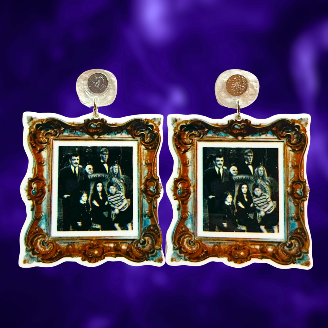 Earrings with a gold frame featuring a black and white photo of the Addams Family, perfect for spooky and gothic fashion lover