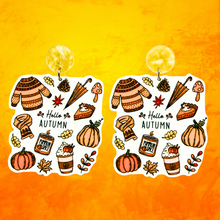 Load image into Gallery viewer, Orange background with earrings with the phrase &#39;Hello Autumn&#39; featuring doodles of a scarf, sweater, pumpkin, leaves, coffee, candles, and pumpkin pie, perfect for cozy fall enthusiasts
