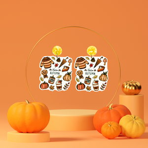 Orange stand with earrings with the phrase 'Hello Autumn' featuring doodles of a scarf, sweater, pumpkin, leaves, coffee, candles, and pumpkin pie, perfect for cozy fall enthusiasts