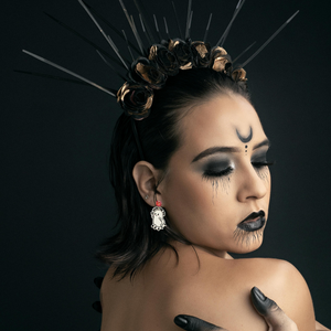 A model dressed in black costume wearing a pair of fun Halloween ghost earrings with the text 'Here for the BOOty,' designed for adding a playful, quirky touch to Halloween accessories and fashion.